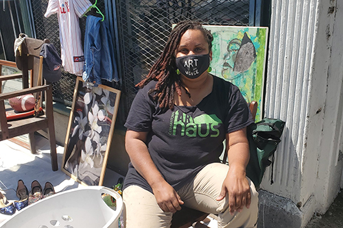 Photo of Keisha sitting on a chair at her flea market.